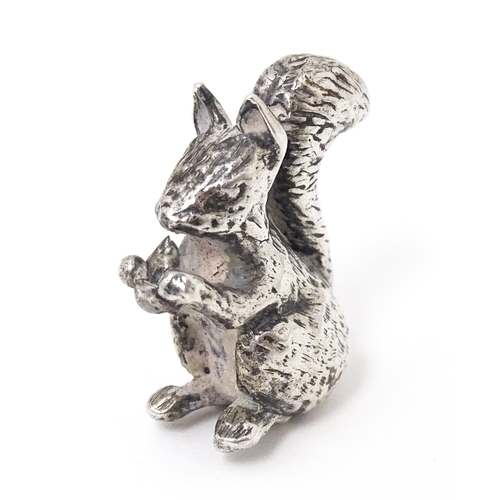 327 - A miniature silver model of a seated squirrel with a nut, hallmarked London 1976. Approx. 1