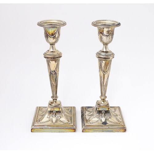 333 - A pair of silver candlesticks with harebell swag and bow decoration. Hallmarked Sheffield 1909 maker... 