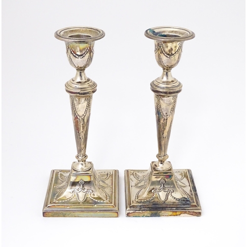 333 - A pair of silver candlesticks with harebell swag and bow decoration. Hallmarked Sheffield 1909 maker... 