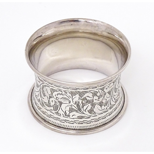 343 - A silver napkin ring with engraved acanthus scroll decoration, hallmarked Birmingham 1906