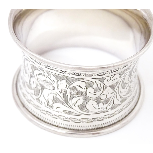 343 - A silver napkin ring with engraved acanthus scroll decoration, hallmarked Birmingham 1906