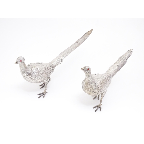 350 - A large pair of silver pheasants modelled as a cock and a hen pheasant with red glass eyes. Hallmark... 