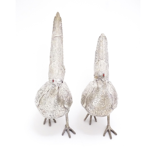 350 - A large pair of silver pheasants modelled as a cock and a hen pheasant with red glass eyes. Hallmark... 