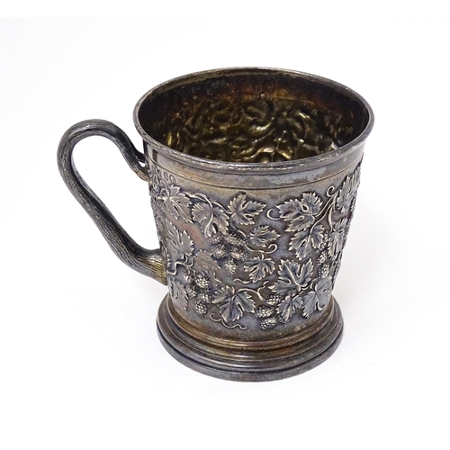 378 - A Victorian silver mug with hop and vine decoration, branch formed handle and gilded interior. Hallm... 