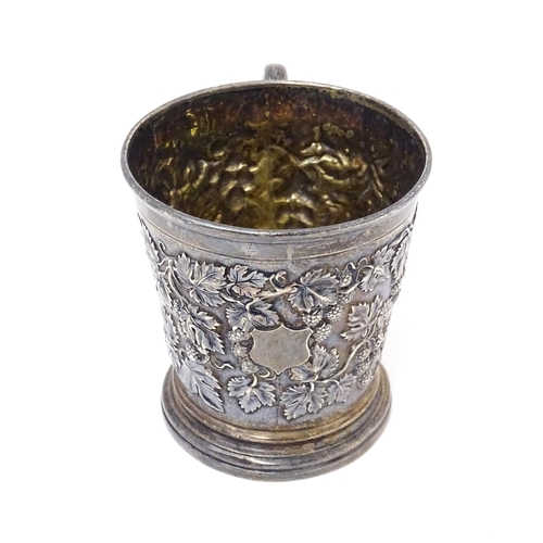 378 - A Victorian silver mug with hop and vine decoration, branch formed handle and gilded interior. Hallm... 