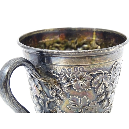 378 - A Victorian silver mug with hop and vine decoration, branch formed handle and gilded interior. Hallm... 