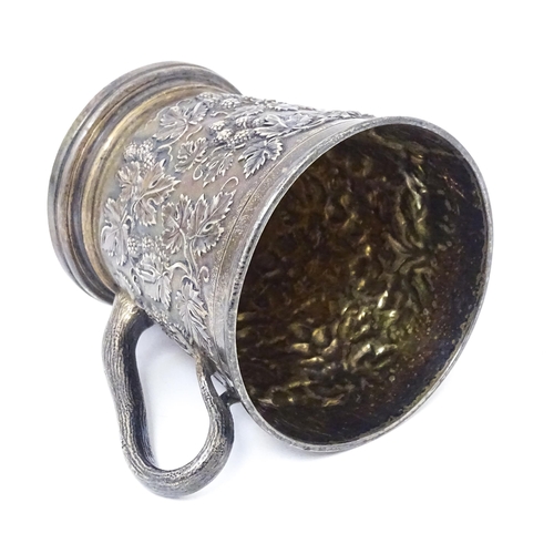 378 - A Victorian silver mug with hop and vine decoration, branch formed handle and gilded interior. Hallm... 