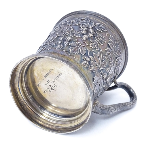 378 - A Victorian silver mug with hop and vine decoration, branch formed handle and gilded interior. Hallm... 