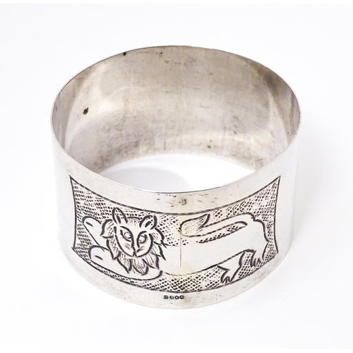 396 - A Continental silver napkin ring with engraved lion decoration, marked S800.