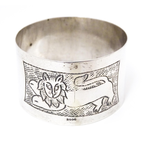 396 - A Continental silver napkin ring with engraved lion decoration, marked S800.