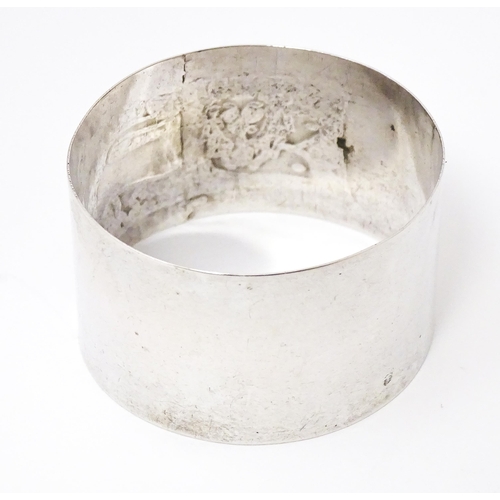 396 - A Continental silver napkin ring with engraved lion decoration, marked S800.