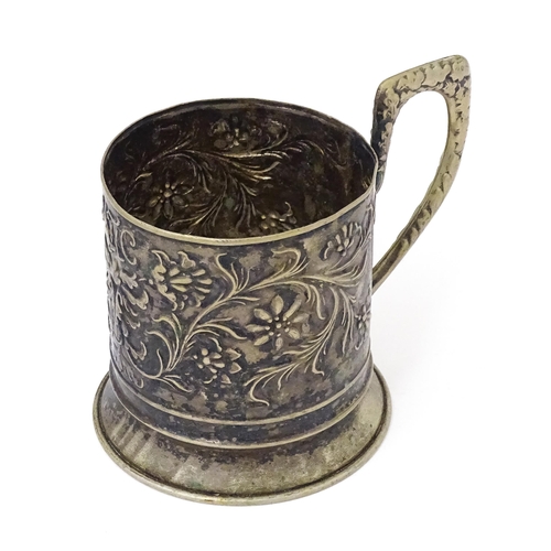 397 - A Continental white metal tisane beaker holder . With floral and foliate detail. Indistinctly marked... 