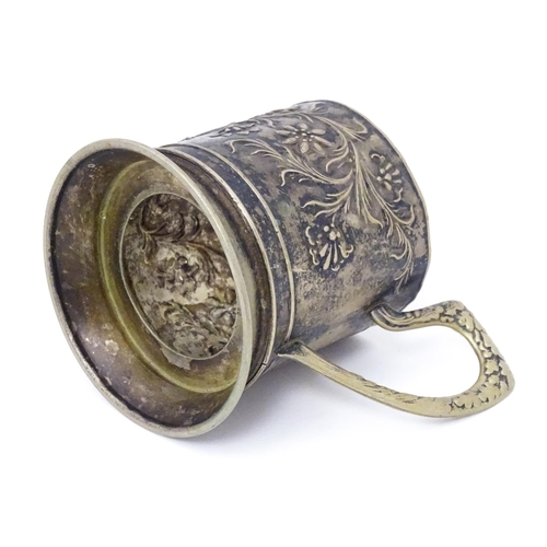 397 - A Continental white metal tisane beaker holder . With floral and foliate detail. Indistinctly marked... 