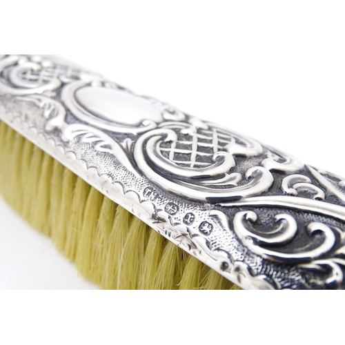 432 - A silver handled brush with embossed decoration, hallmarked Birmingham 1899, maker Thomas Hayes. Tog... 