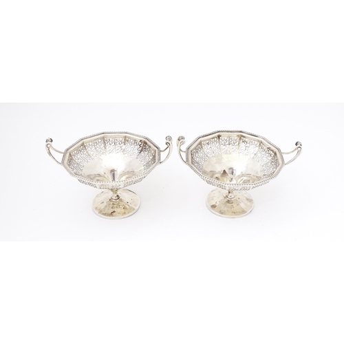 444 - A pair of silver bon bon dished of pedestal form with pierced decoration and twin handles. Hallmarke... 