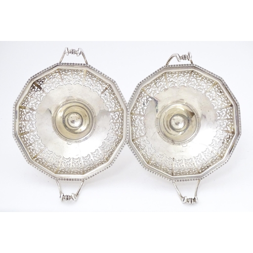 444 - A pair of silver bon bon dished of pedestal form with pierced decoration and twin handles. Hallmarke... 