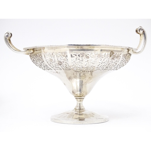 444 - A pair of silver bon bon dished of pedestal form with pierced decoration and twin handles. Hallmarke... 