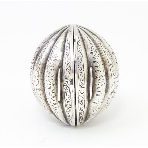 451 - A Victorian silver nutmeg grater of melon form with engraved detail. Hinging open to reveal grater w... 