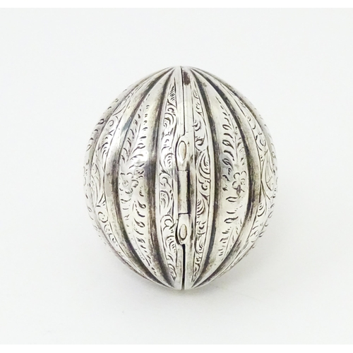 451 - A Victorian silver nutmeg grater of melon form with engraved detail. Hinging open to reveal grater w... 