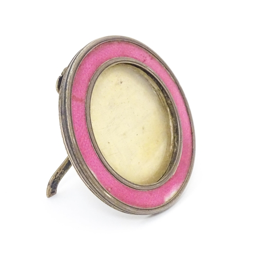 458 - A silver easel back photograph frame of circular form with pink guilloche enamel decoration. Hallmar... 