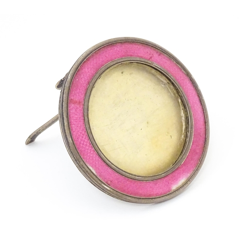 458 - A silver easel back photograph frame of circular form with pink guilloche enamel decoration. Hallmar... 