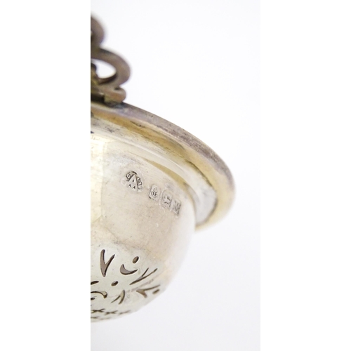 471 - A silver twin handled lemon / tea strainer with pierced detail and bowl under. Hallmarked Birmingham... 