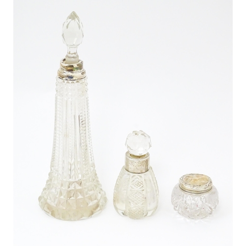 509 - Three cut glass dressing table bottles / pots. The tallest hallmarked London 1913. Approx 7