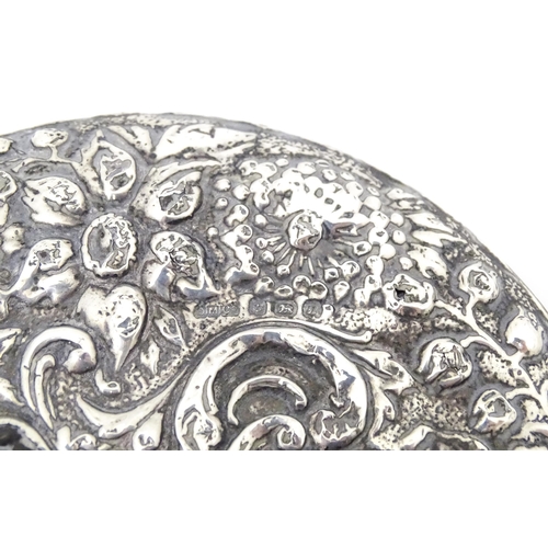 552 - A Victorian silver backed hand mirror with embossed floral and foliate decoration, hallmarked Birmin... 