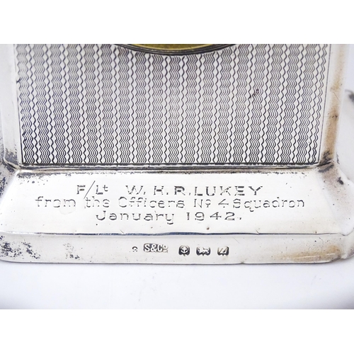 560 - WWII RAF interest : A silver cased mantle clock with engine turned decoration and inscription to ' F... 