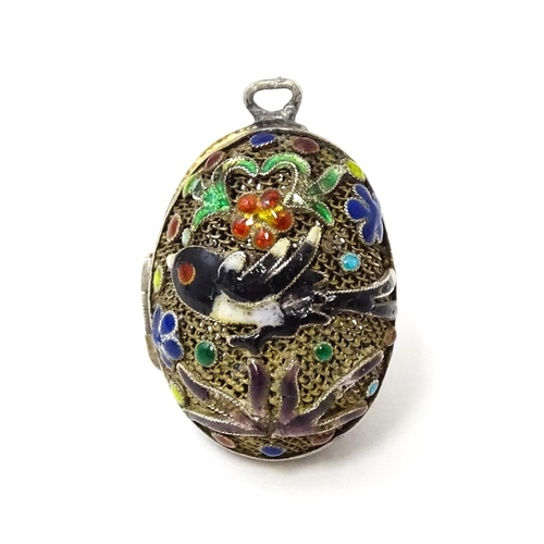 687 - A gilt metal pendant / vinaigrette of egg form with enamel bird and floral detail Approx 1 1/42 long