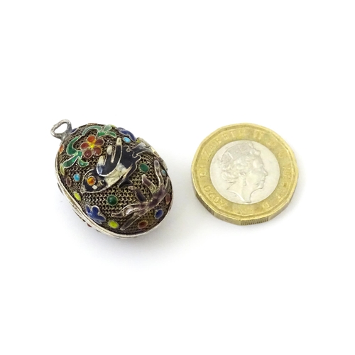 687 - A gilt metal pendant / vinaigrette of egg form with enamel bird and floral detail Approx 1 1/42 long