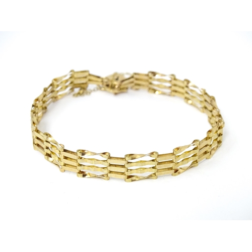 689 - A gold bracelet with padlock formed clasp.