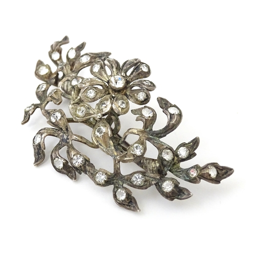 692 - A white metal brooch  of floral and foliate form set with paste detail. Approx 3