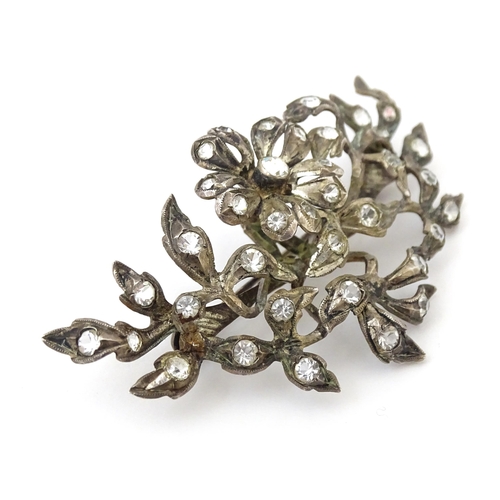 692 - A white metal brooch  of floral and foliate form set with paste detail. Approx 3