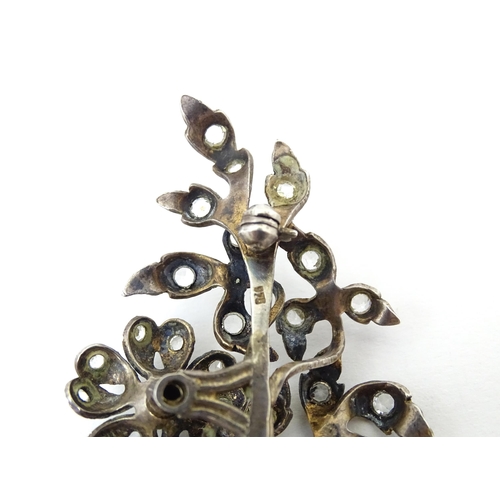 692 - A white metal brooch  of floral and foliate form set with paste detail. Approx 3