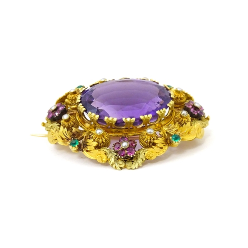 693 - An impressive Victorian brooch set with large central amethyst within a floral and foliate mount set... 