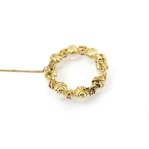 701 - A 9ct gold pendant / brooch of circular set with pearls and round cut rubies. Approx 1