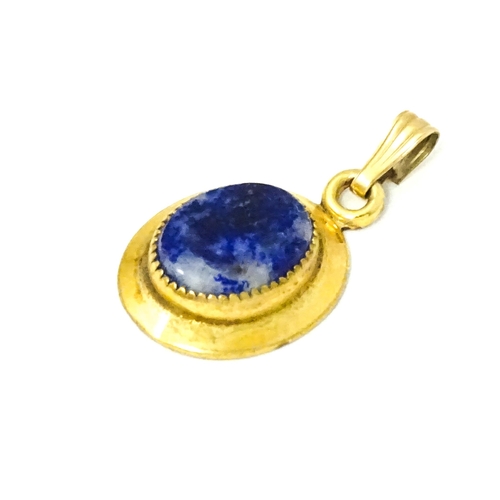 702 - A Continental gilt metal pendant with lapiz lazuli set to centre 3/4