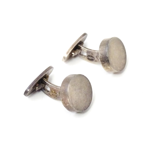 704 - A pair of Danish silver cufflinks by Georg Jensen. Marked 925 S Denmark and numbered 'A24'