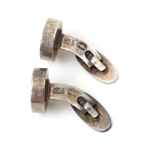 704 - A pair of Danish silver cufflinks by Georg Jensen. Marked 925 S Denmark and numbered 'A24'