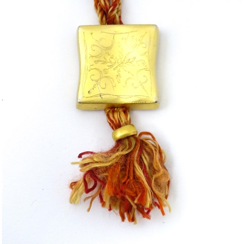 709 - A necklace of twisted orange and golden coloured thread form with gilt metal sliders and pendant mar... 