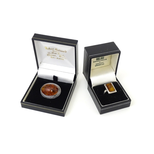 724 - A white metal ring set with amber, together with an oval brooch. Ring size approx M.  (2)