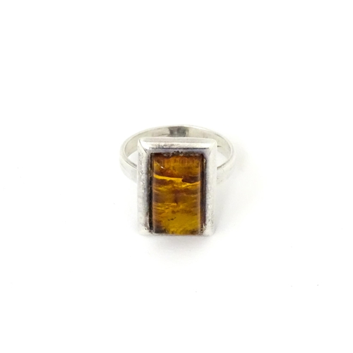 724 - A white metal ring set with amber, together with an oval brooch. Ring size approx M.  (2)