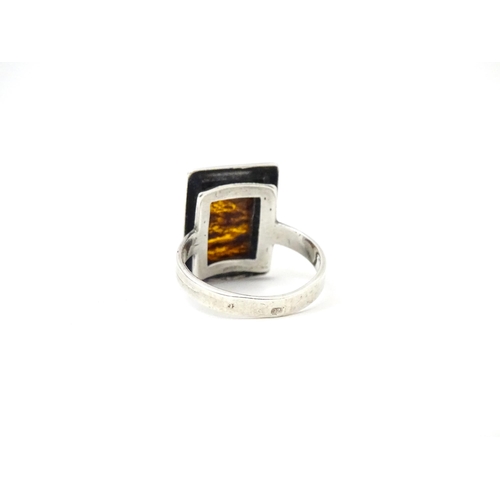 724 - A white metal ring set with amber, together with an oval brooch. Ring size approx M.  (2)