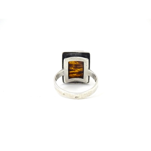 724 - A white metal ring set with amber, together with an oval brooch. Ring size approx M.  (2)