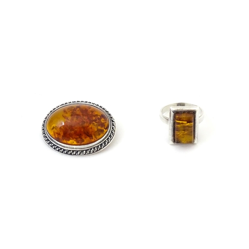 724 - A white metal ring set with amber, together with an oval brooch. Ring size approx M.  (2)