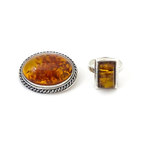 724 - A white metal ring set with amber, together with an oval brooch. Ring size approx M.  (2)