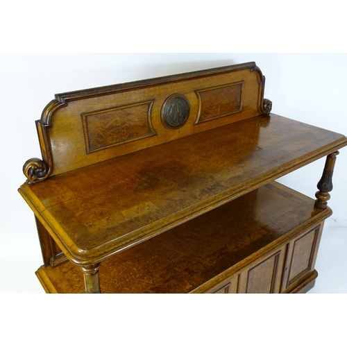 1598 - A late 19thC oak buffet, with a shaped upstand, carved edges, burr panels and carved roundel to the ... 