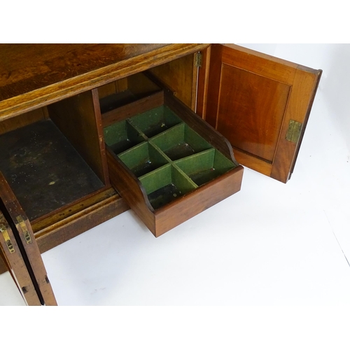 1598 - A late 19thC oak buffet, with a shaped upstand, carved edges, burr panels and carved roundel to the ... 