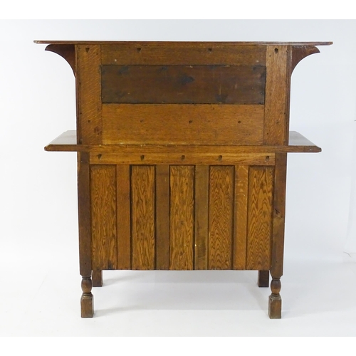1605 - A late 19thC oak Arts and Crafts sideboard, attributed to Liberty & Co. Having a flat cornice above ... 